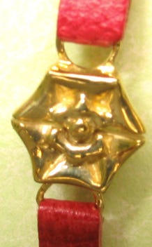 Close up view of bronze clasp in shape of tudor rose.